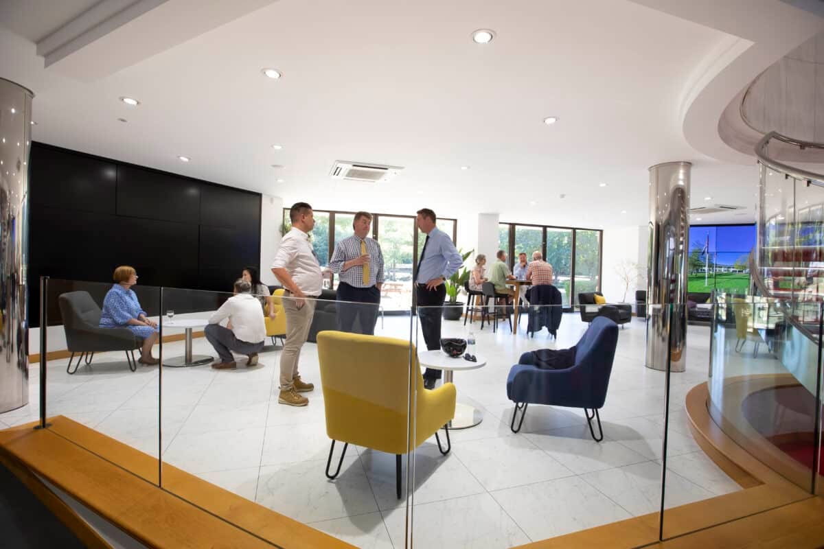 The light-filled atrium lounge with members chatting