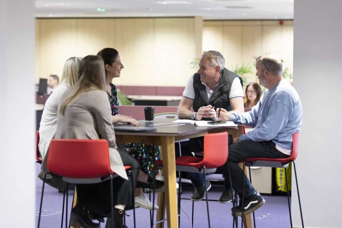 A group of members talking around a high table