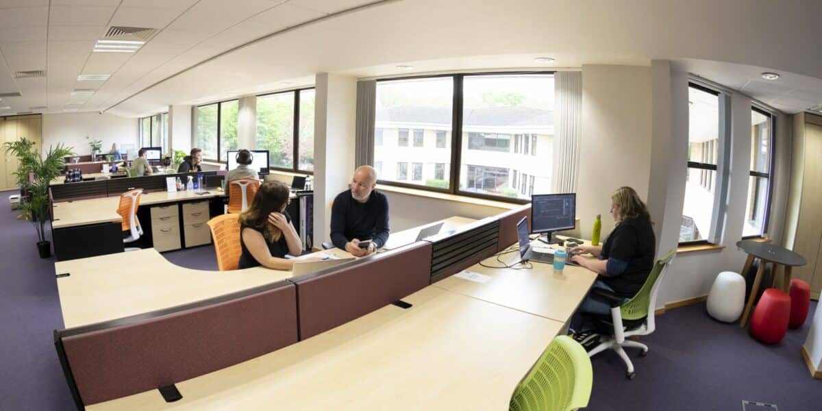 A bright, curved open-plan office with views over the grounds
