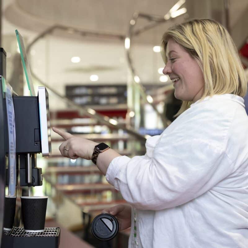 A member smiling at the on-site coffee machine