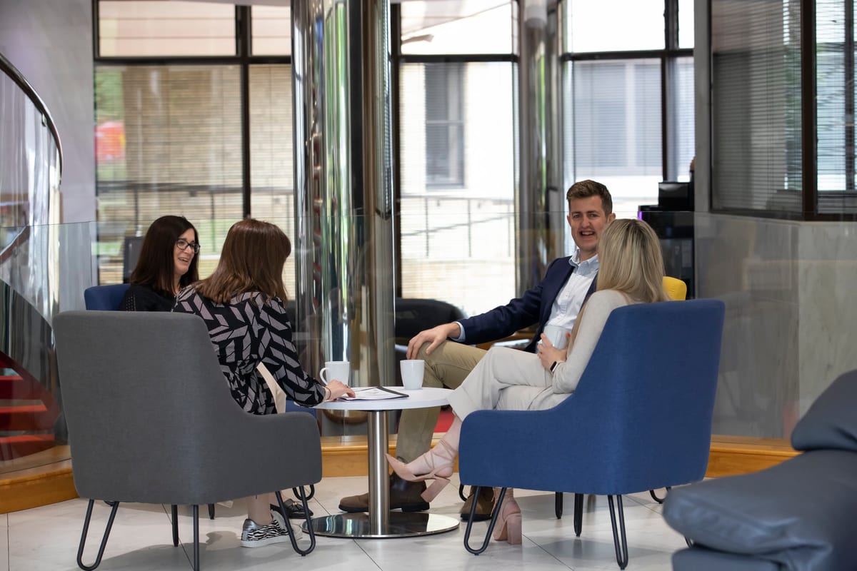 Members chatting in the business lounge armchairs