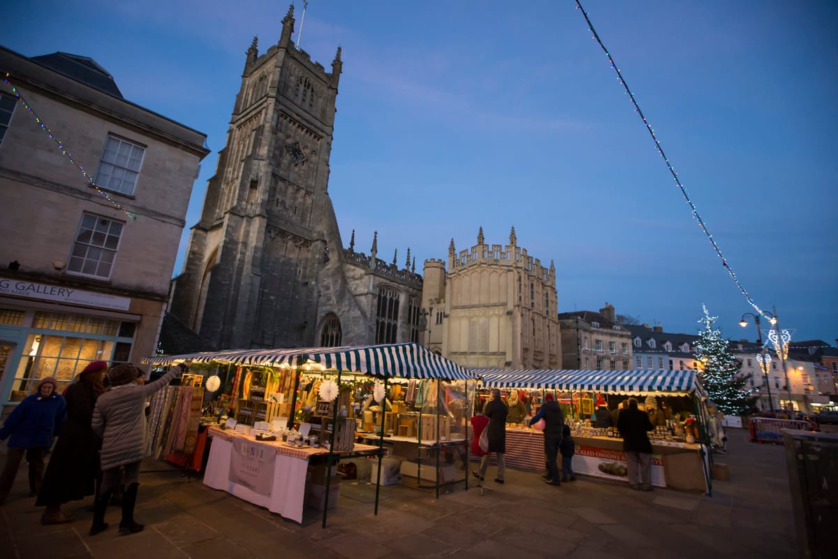 The Christmas market beside Cirencester parish church at dusk