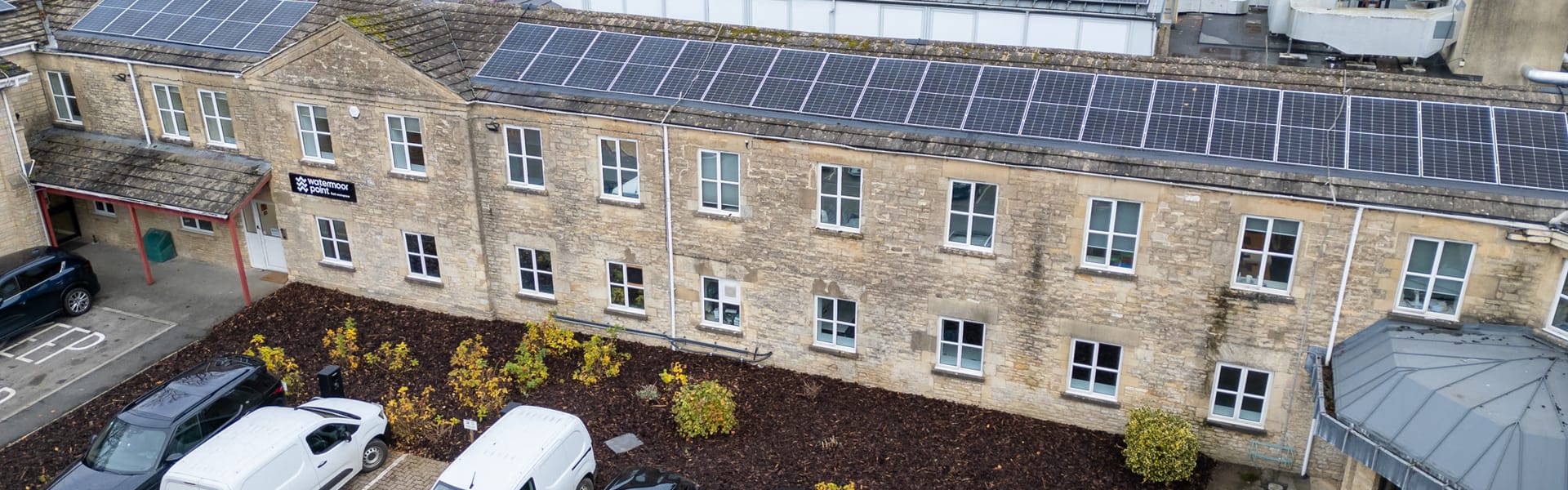 The Cotswold-stone Trinity Road building from above, with rooftop solar panels