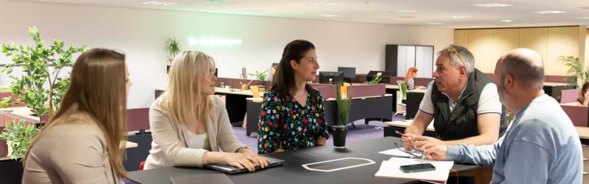 A team of five collaborating around a meeting table at Watermoor Point