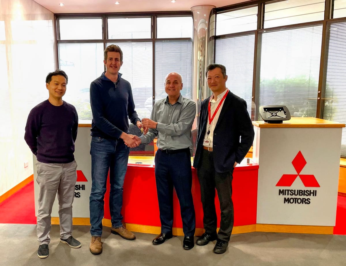 People shaking hands at the Mitsubishi Motors UK handover