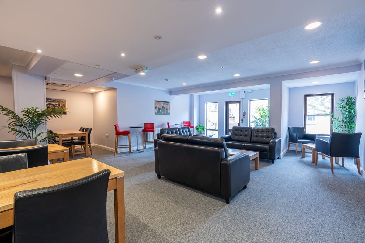 The shared lounge at Riverside Hotel with sofas and dining tables