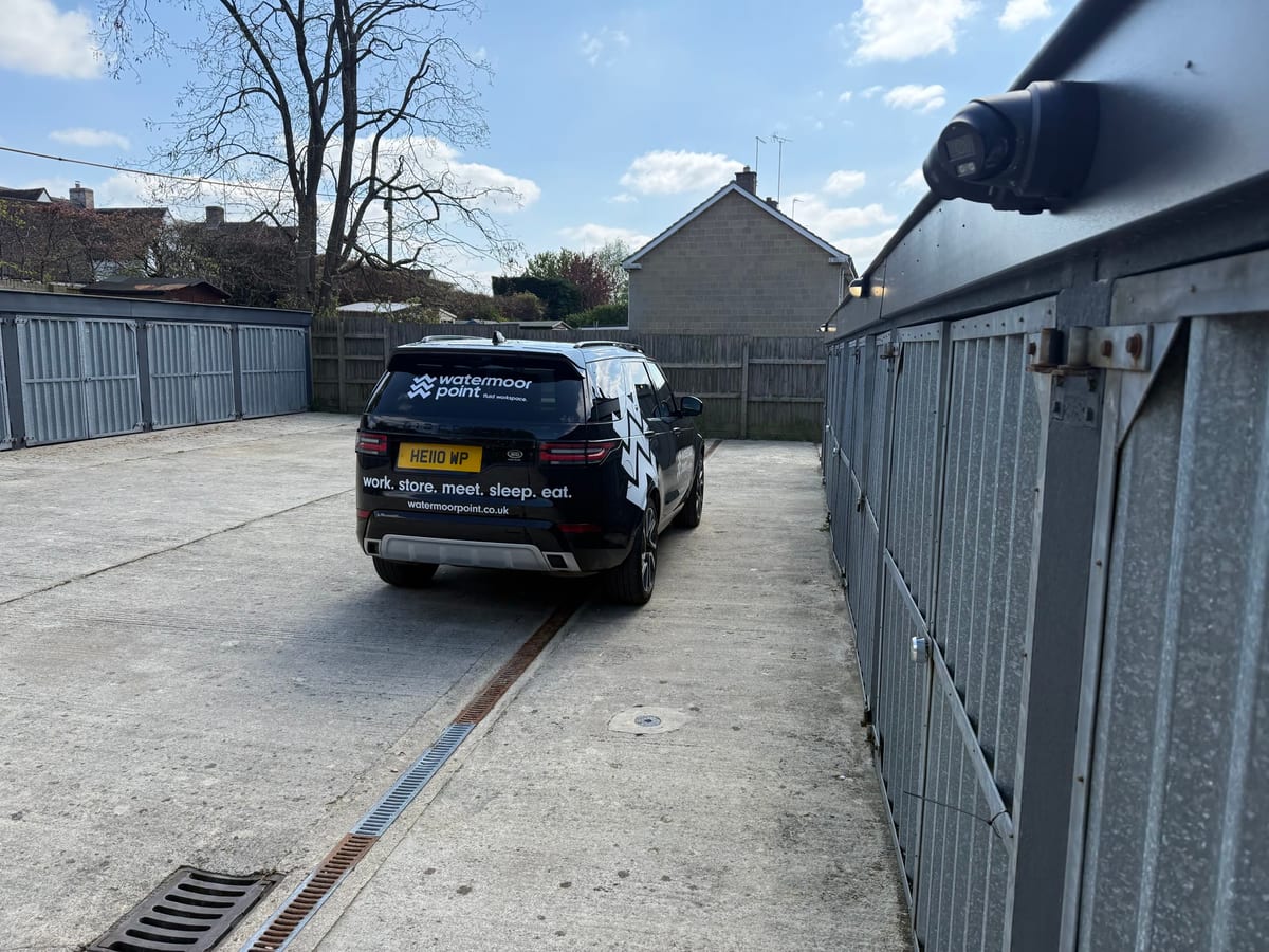 A lock-up garage at Watermoor Point with a vehicle parked alongside